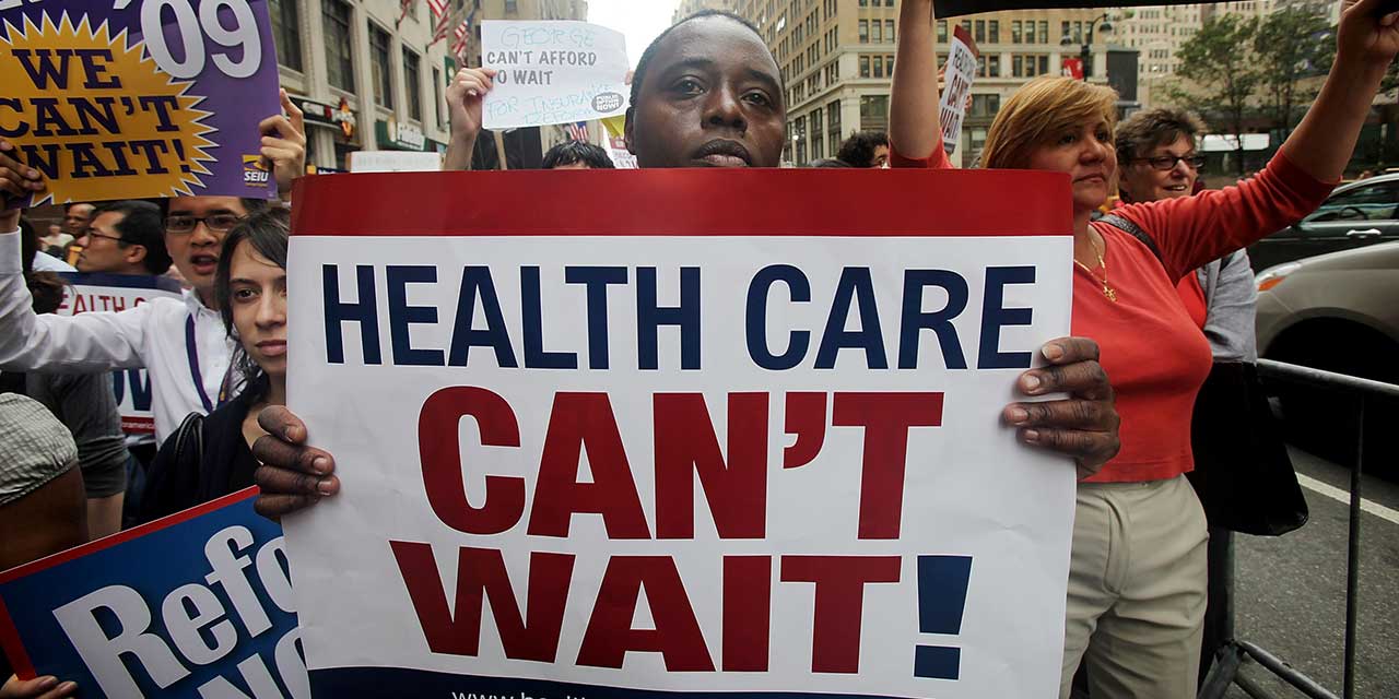 demo with sign saying 'Health Care Can't Wait'